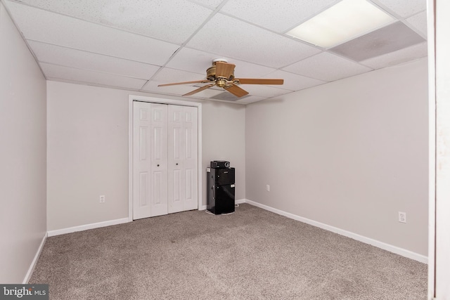 unfurnished bedroom with a closet, baseboards, carpet, and a drop ceiling