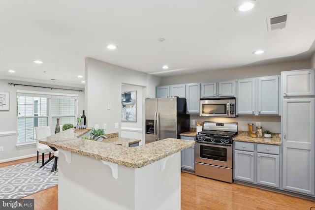 6603 Netties Ln Unit 1706, Alexandria, VA 22315 - kitchen featuring stainless steel appliances, a kitchen bar, gray cabinetry, light wood-type flooring, and recessed lighting