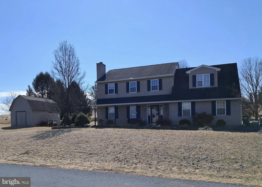 view of front facade with an outbuilding and a chimney