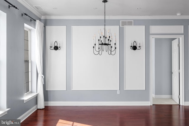 unfurnished dining area featuring visible vents, wood finished floors, crown molding, baseboards, and a chandelier