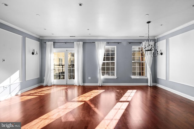 unfurnished dining area with baseboards, an inviting chandelier, wood finished floors, and crown molding