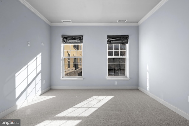 carpeted spare room featuring visible vents, baseboards, and ornamental molding