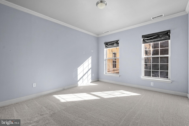 carpeted spare room featuring visible vents, baseboards, and crown molding