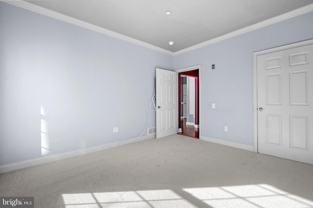 unfurnished bedroom featuring baseboards, carpet floors, visible vents, and ornamental molding