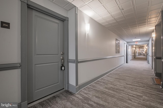 hallway with visible vents, baseboards, and carpet floors