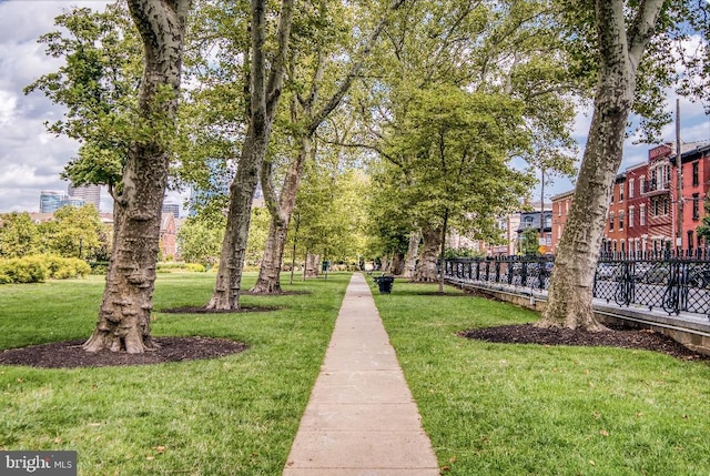 view of home's community featuring a lawn and fence