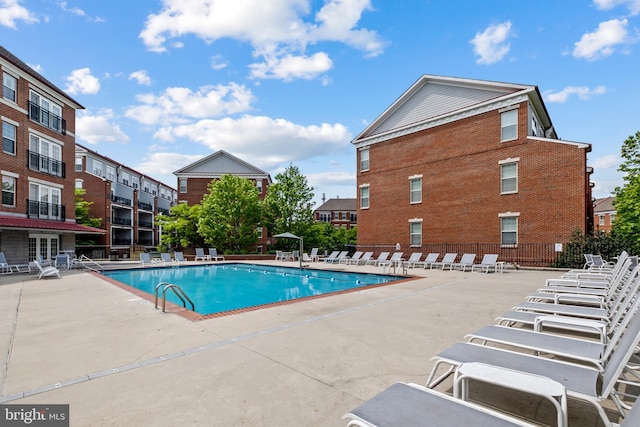 pool with a patio and fence