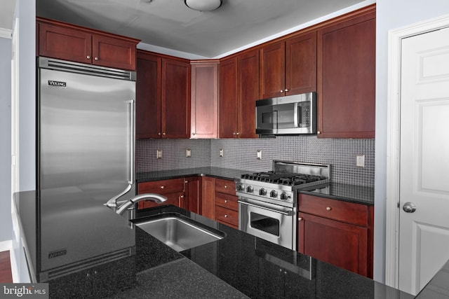 kitchen featuring dark brown cabinets, dark stone counters, decorative backsplash, high end appliances, and a sink