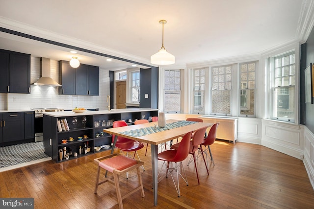 dining area featuring dark wood-style floors, plenty of natural light, radiator, and crown molding