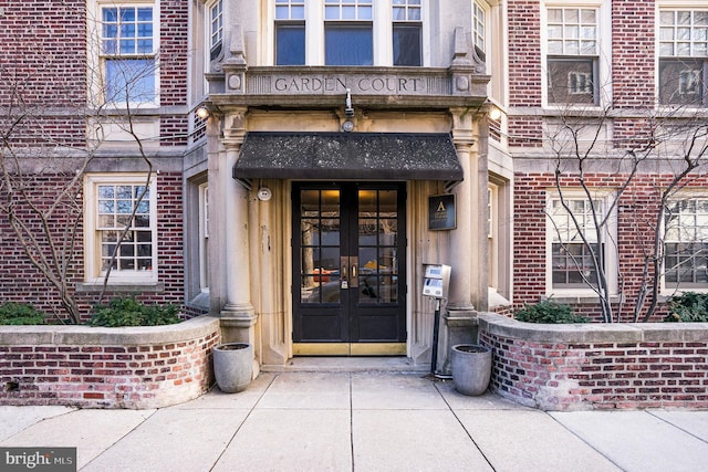 view of exterior entry with brick siding and french doors