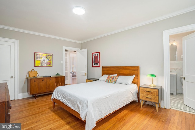 bedroom featuring ensuite bath, baseboards, light wood finished floors, and ornamental molding