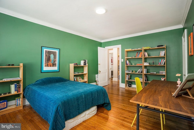 bedroom featuring ornamental molding, baseboards, and wood-type flooring