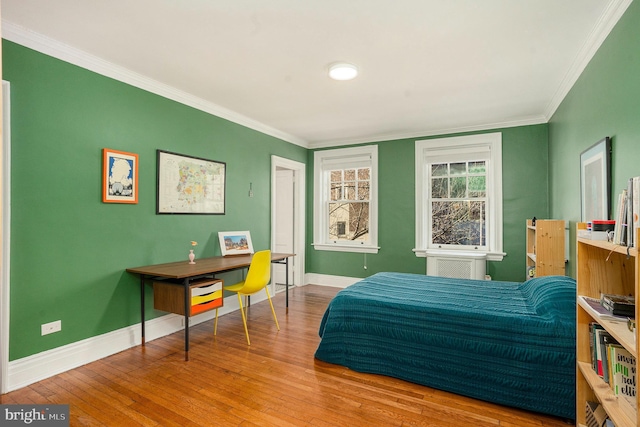 bedroom with ornamental molding, baseboards, and hardwood / wood-style floors