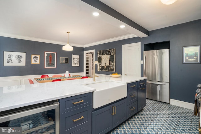 kitchen with beverage cooler, beamed ceiling, decorative light fixtures, freestanding refrigerator, and a sink