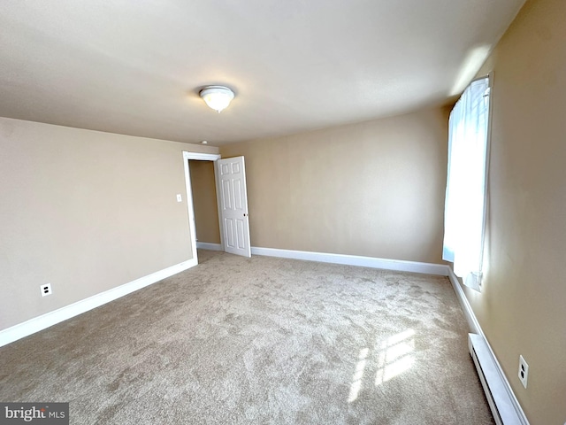 spare room with baseboards, carpet floors, and a baseboard radiator