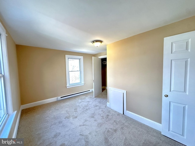 empty room with baseboard heating, baseboards, and carpet