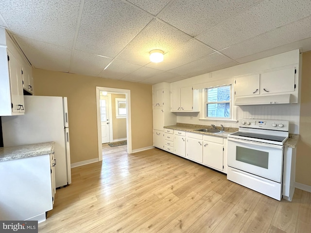 kitchen with white appliances, a sink, light countertops, white cabinets, and under cabinet range hood