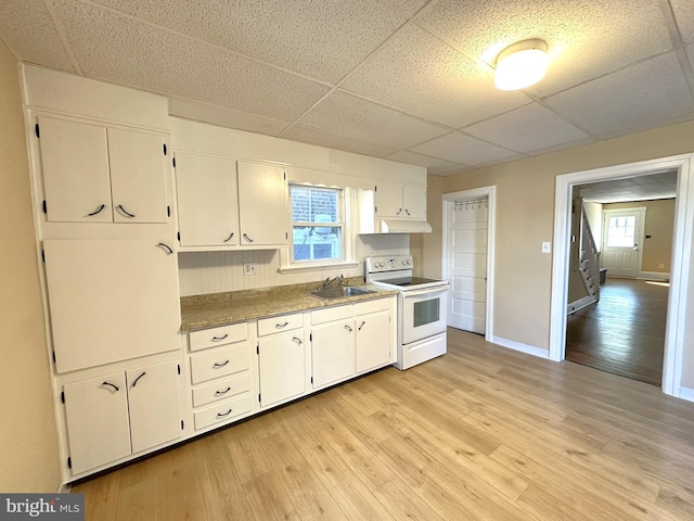 kitchen featuring a sink, white cabinetry, light wood-style flooring, and electric stove