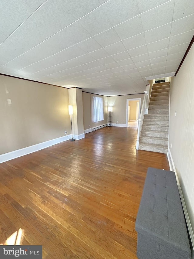 unfurnished living room with baseboards, wood finished floors, and stairs