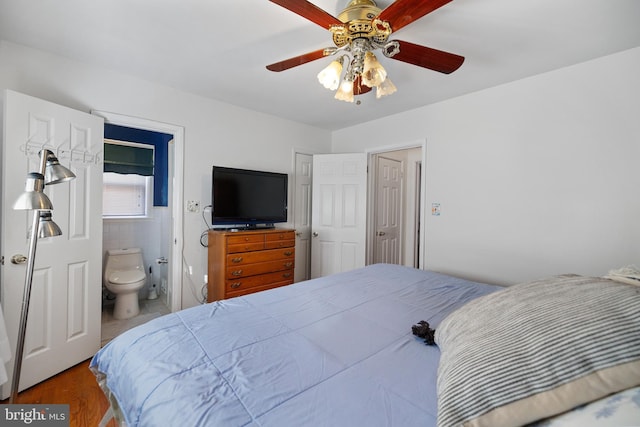 bedroom with ceiling fan, ensuite bath, and wood finished floors