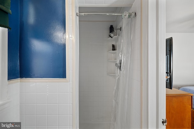 full bathroom with tile walls and a shower stall