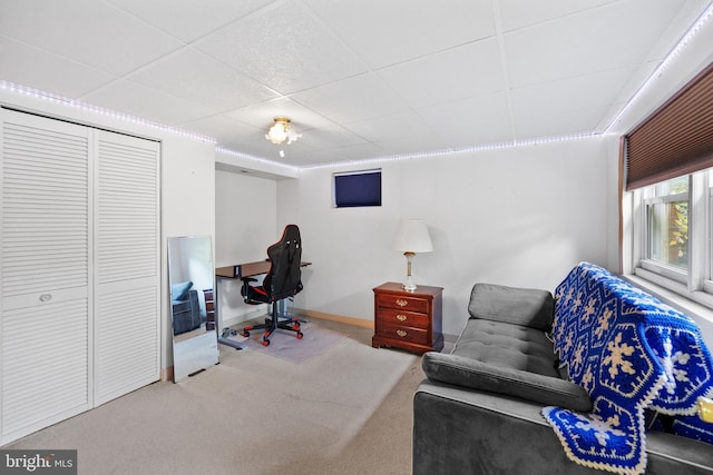 carpeted office with a paneled ceiling and baseboards