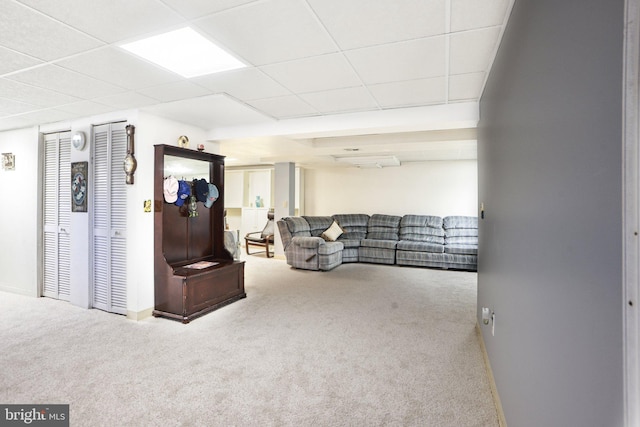 interior space with a paneled ceiling and baseboards