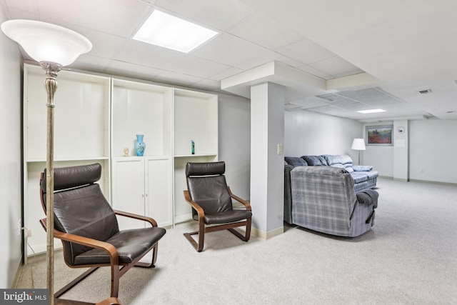 living area with visible vents, light colored carpet, baseboards, and a drop ceiling