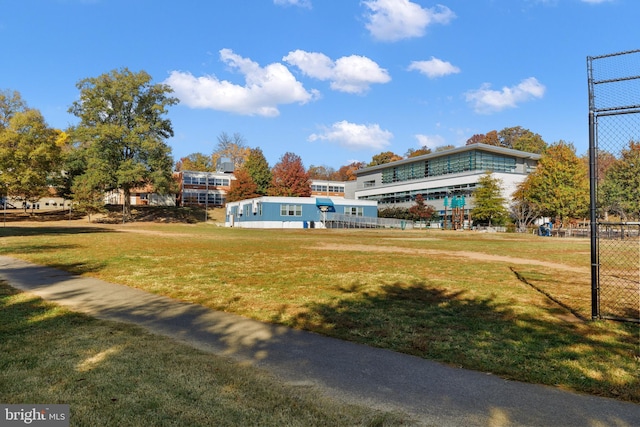 view of property's community with a lawn and fence