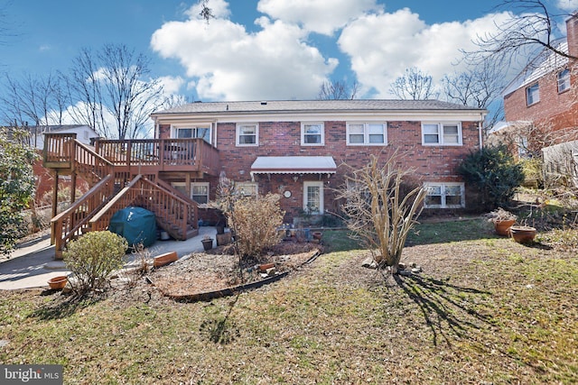 view of front of house with stairs, a deck, and brick siding