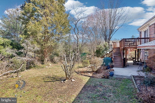 view of yard with stairs, a patio, and a wooden deck