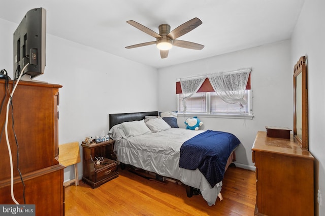 bedroom with baseboards, light wood-type flooring, and ceiling fan