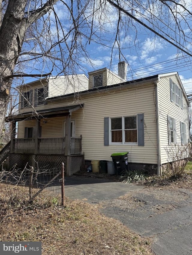 exterior space featuring covered porch and a chimney