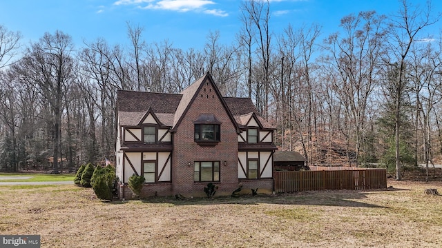 view of front of house with brick siding, stucco siding, a front lawn, and roof with shingles