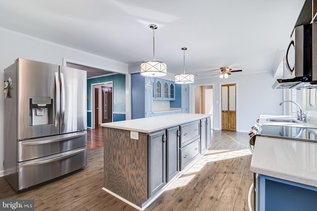 kitchen featuring crown molding, a center island, wood finished floors, and stainless steel appliances