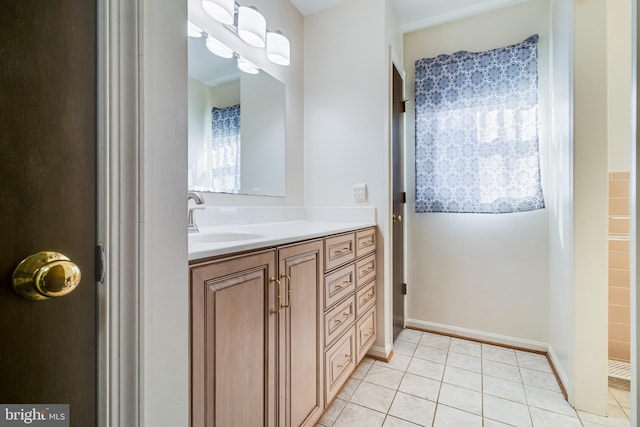 bathroom with baseboards, vanity, and tile patterned flooring