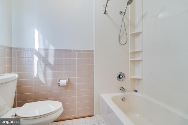 bathroom with toilet, tile walls, bathing tub / shower combination, and tile patterned flooring