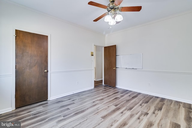 unfurnished room featuring ceiling fan, wood finished floors, baseboards, and ornamental molding