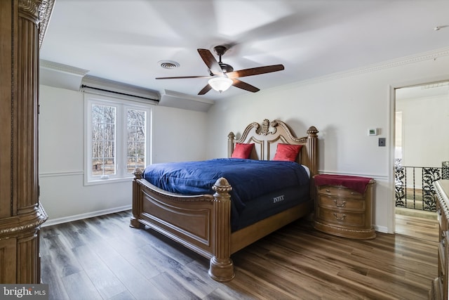 bedroom with dark wood finished floors, visible vents, baseboards, and ornamental molding