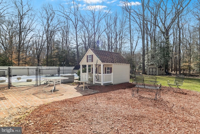 view of outdoor structure featuring fence, an outdoor structure, and a gate