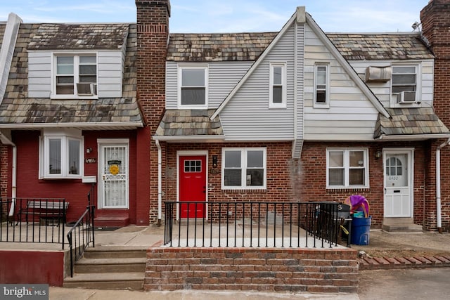 view of property with entry steps, brick siding, and a chimney