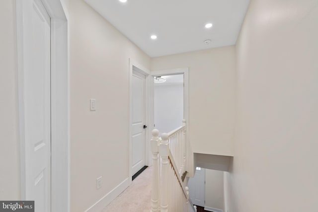 corridor with recessed lighting, baseboards, an upstairs landing, and carpet floors