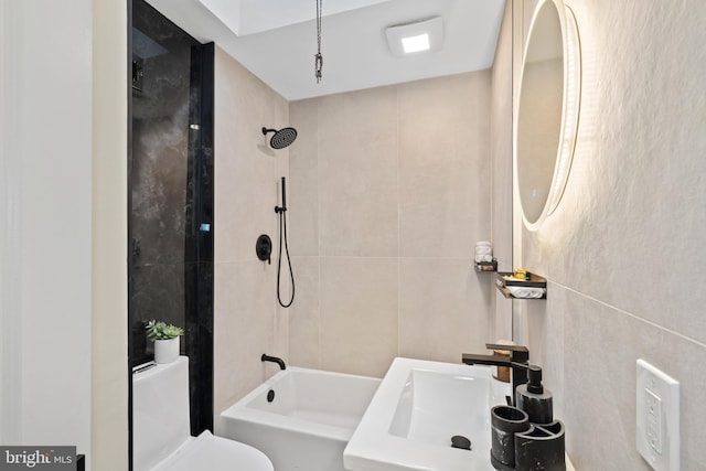 full bathroom featuring a sink, shower / bath combination, toilet, and tile walls