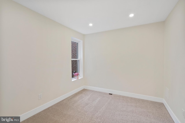 unfurnished room with recessed lighting, baseboards, and light carpet