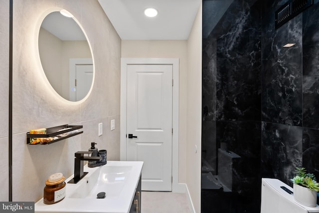 bathroom featuring walk in shower, toilet, tile walls, and vanity