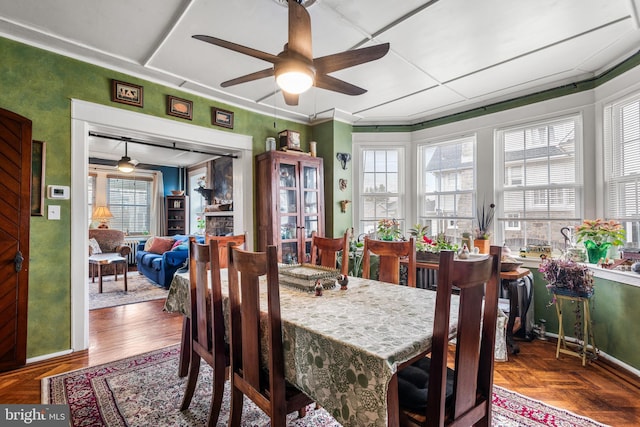 dining space featuring ceiling fan and parquet flooring