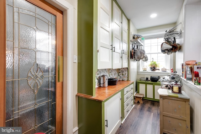 kitchen with tasteful backsplash, dark wood-type flooring, and white cabinets