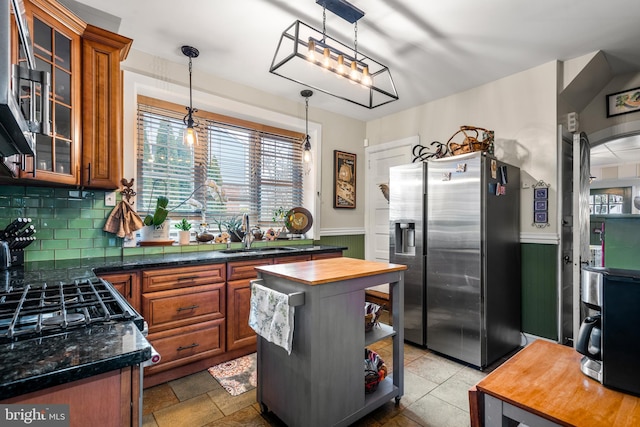 kitchen featuring brown cabinetry, stainless steel fridge, wooden counters, and a sink