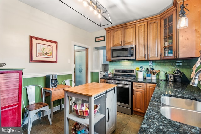 kitchen with open shelves, a sink, decorative backsplash, appliances with stainless steel finishes, and butcher block counters