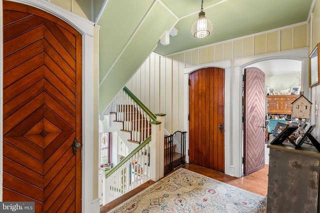 foyer entrance featuring stairs, wood finished floors, and arched walkways